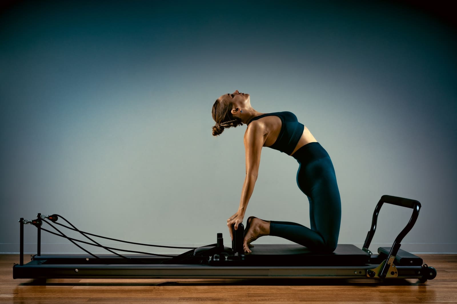 Pilates practitioner in a camel pose on a reformer