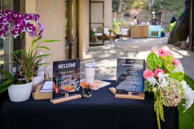 Welcome table at the studio entrance with orchids, flowers, and Hiptwist signage
