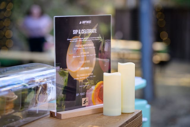 &ldquo;Sip & Celebrate&rdquo; menu sign and candles on the bar