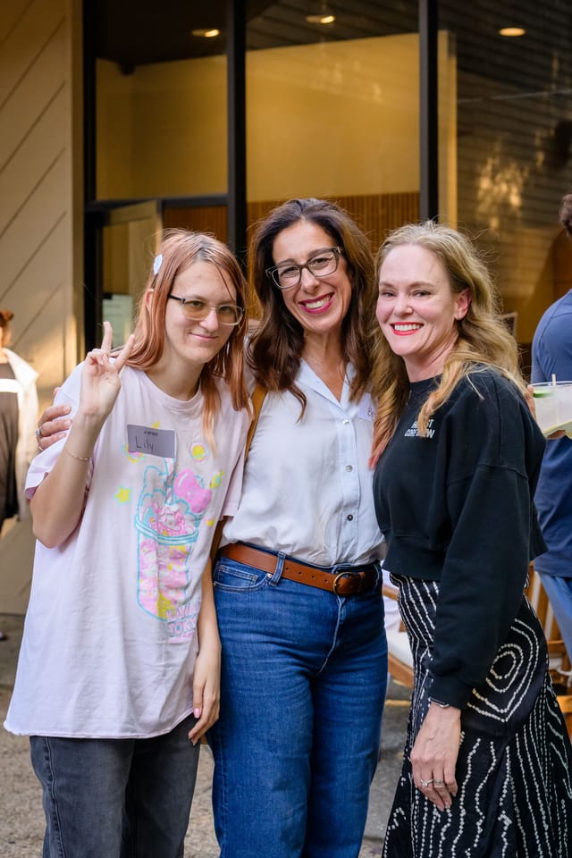 Three guests smiling together outside the studio