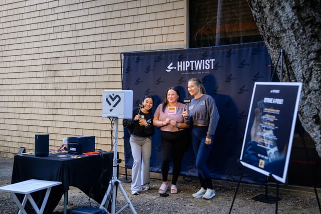 Guests posing at the Hiptwist photo booth backdrop